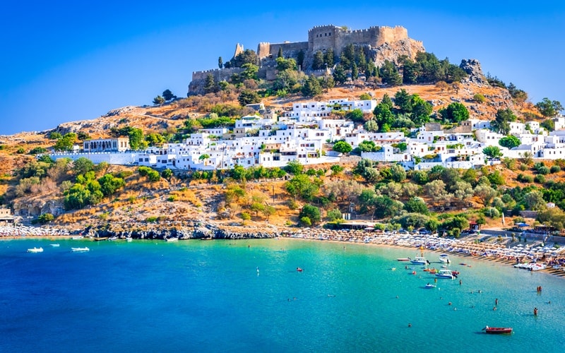Rhodos-Stadt mit dem Meer, weißen Häusern und der Festung auf einem Hügel.