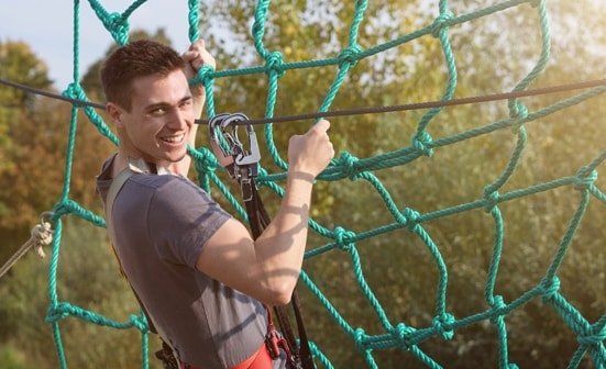Mann klettert durch Netzte