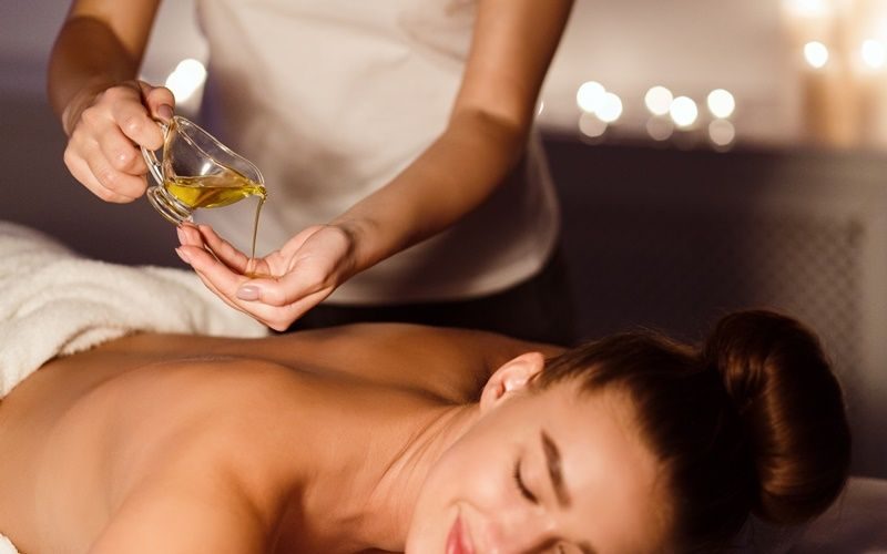Eine Frau entspannt sich bei einer Aromaöl-Massage.