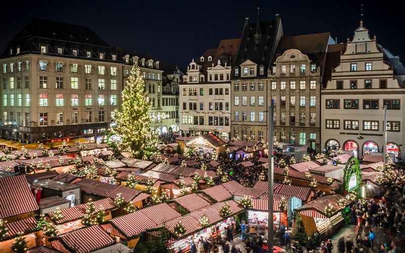 Der Leipziger Marktplatz mit Weihnachtsmarktständen und vielen Lichtern.